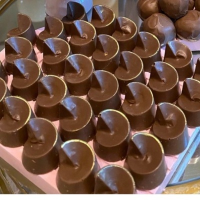 Caixa de bombons de chocolate em forma de coração sobre superfície espelhada