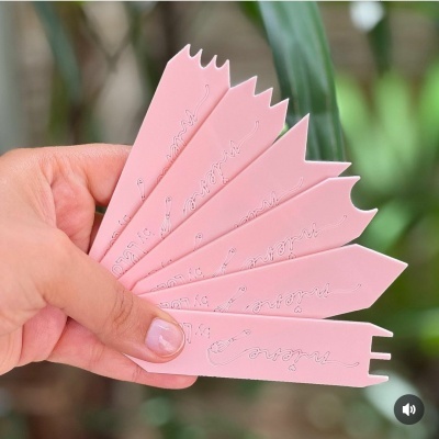 Sete tiras plásticas rosa com inscrições em relevo, seguradas por uma mão