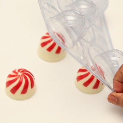 Forma de silicone transparente com doces brancos e vermelhos