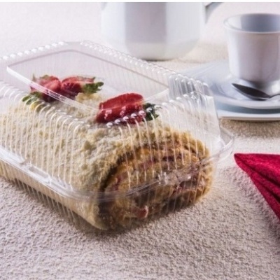 Pão-de-ló em rolo com morangos em embalagem plástica com chávenas e guardanapo