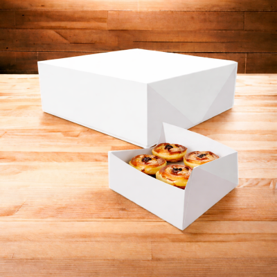 Caixa branca com quatro pastéis de nata em madeira clara