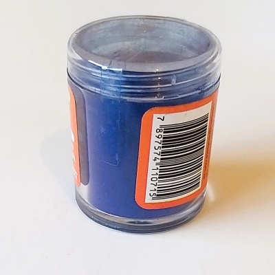 Frasco plástico com pó azul e etiqueta com código de barras