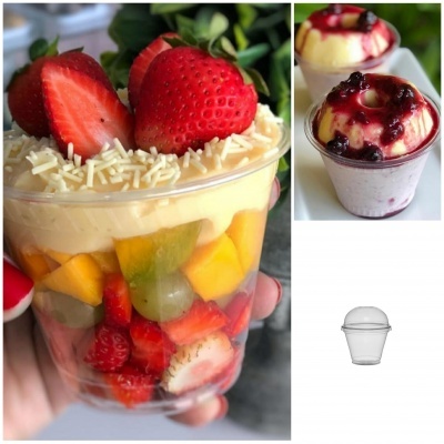 Copos de sobremesa com fruta e creme em fundo claro.