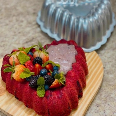 Bolo em forma de coração com frutas frescas e forma metálica ao fundo