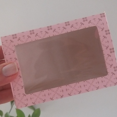Caixa rosa com padrão de tesouras e janela transparente