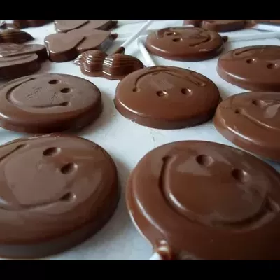 Chocolates redondos e sorridentes sobre superfície branca