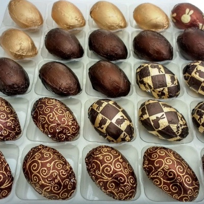 Ovos de chocolate com diferentes padrões e cores num tabuleiro plástico.