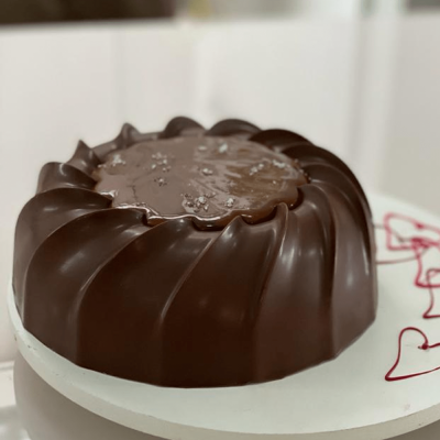 Bolo de chocolate redondo com decoração prateada em base branca