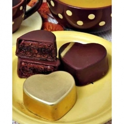 Caixas de chocolate em forma de coração com recheio em prato amarelo