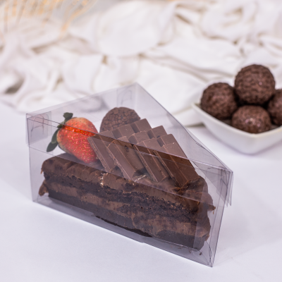 Fatia de bolo de chocolate embalada com morango e pedaços de chocolate