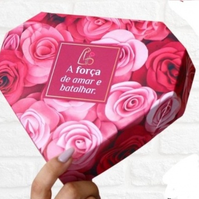 Caixa decorada com rosas e frase inspiradora, segurada por mão feminina