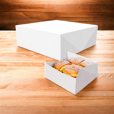 Caixa branca com mini donuts recheados polvilhados com açúcar em pó sobre mesa de madeira.