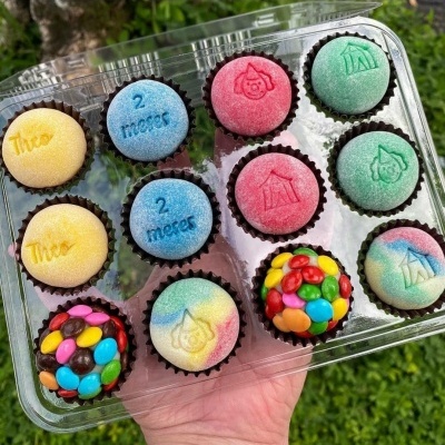 Pack de brigadeiros coloridos com textos e desenhos em embalagem transparente