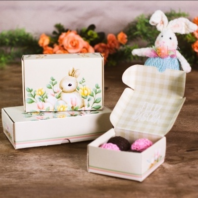 Caixa decorada com bombons e coelho peluche ao fundo