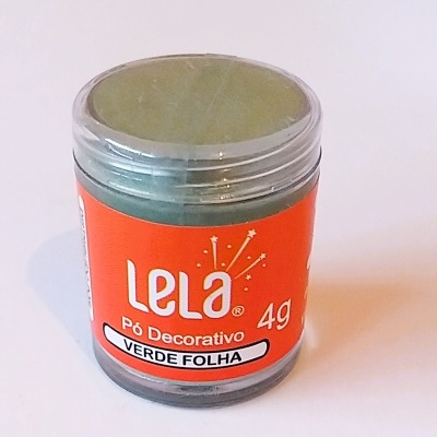 Frasco com pó decorativo verde da marca Lela com etiqueta laranja