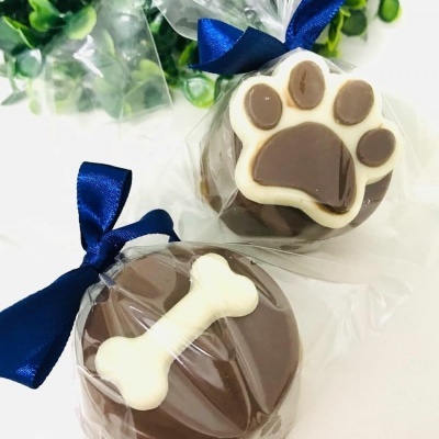 Dois doces de chocolate decorados, embalados com fita azul