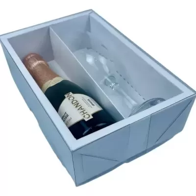 Caixa branca com garrafa de champanhe e taça de vidro