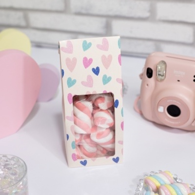 Caixa decorativa com marshmallows e objetos em fundo branco