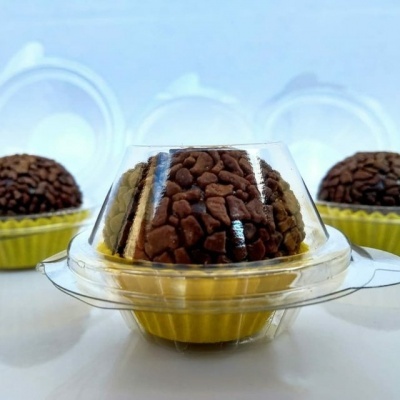 Doce em forma de cúpula com cobertura castanha em embalagem plástica