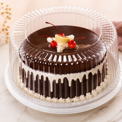 Bolo de chocolate com decoração de chantilly e cerejas dentro de embalagem plástica transparente