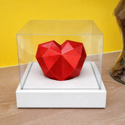Coração geométrico vermelho em caixa transparente com base branca