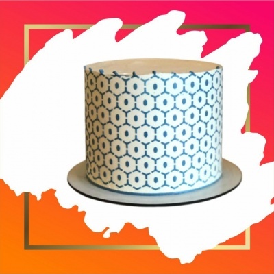 Bolo decorado branco e azul num prato sobre fundo vermelho e laranja