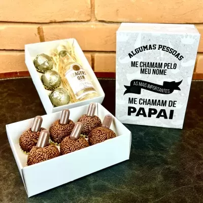 Caixa branca com brigadeiros, mini frascos, garrafa de ginebra e bombons dourados com caixa decorada com texto para pai.