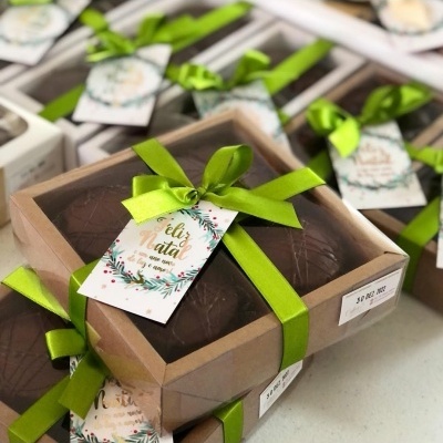 Caixas de ovos de chocolate com fita verde e etiqueta de Feliz Natal.
