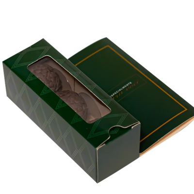 Embalagem verde com três chocolates em barra visíveis e folheto verde com moldura dourada.