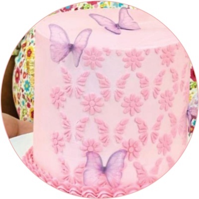 Bolo rosa com decoração de flores em relevo e borboletas lilás