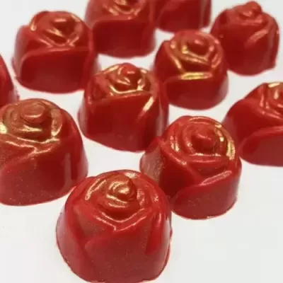 Bombons vermelhos em forma de rosa com detalhes dourados