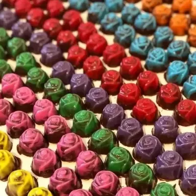 Peças pequenas em forma de rosas coloridas organizadas em fileiras