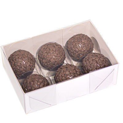 Seis bombons redondos de chocolate em caixa branca.