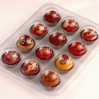 Embalagem com 15 doces coloridos em forminhas pretas