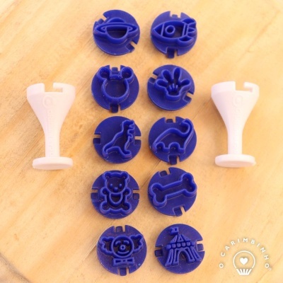 Cortadores de plástico azul e moldes brancos para bolachas com vários desenhos em madeira clara