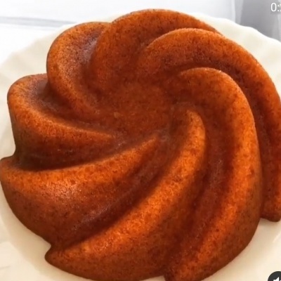 Bolo dourado em forma de redemoinho num prato branco