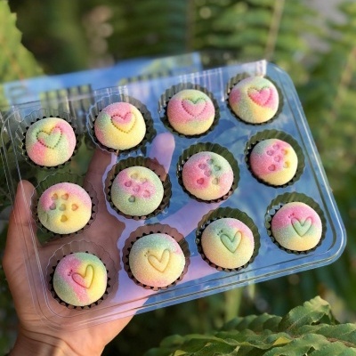 Mini bolos coloridos com padrões em caixa plástica transparente