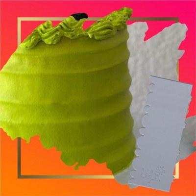 Bolo verde com glacê decorativo e utensílio branco Lelit, fundo colorido.