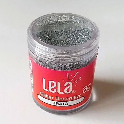 Frasco de glitter decorativo prateado Lela 8g com tampa transparente.