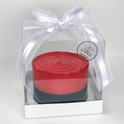 Bolo bicolor vermelho e preto em embalagem transparente com fita branca