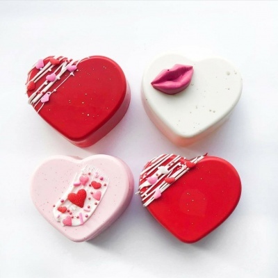 Quatro caixas de coração decoradas em vermelho, branco e rosa, com detalhes de corações e lábios.