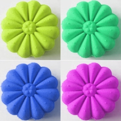 Quatro blocos de areia em forma de flores coloridas sobre fundo branco