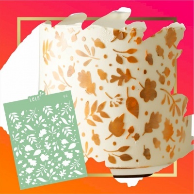 Molde stencil verde com padrão floral ao lado de objeto branco decorado com flores laranjas