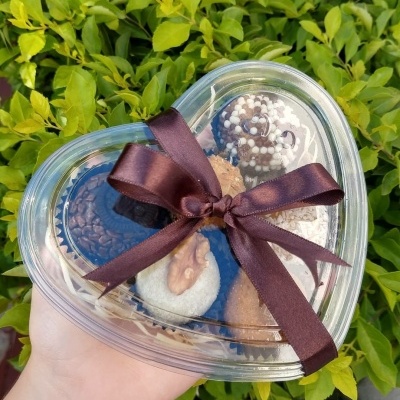 Caixa coração transparente com brigadeiros variados e fita castanha