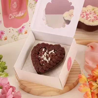 Sobremesa em forma de coração de chocolate numa caixa branca com tampa transparente
