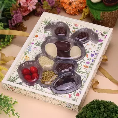 Embalagem em forma de coelho com chocolates e frutos artificiais, fundo floral colorido