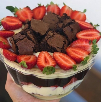 Sobremesa em taça de vidro com morangos e brownies cortados