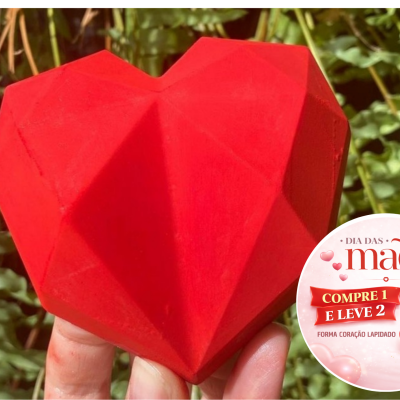 Coração vermelho lapidado segurado à mão com selo promocional de Dia das Mães