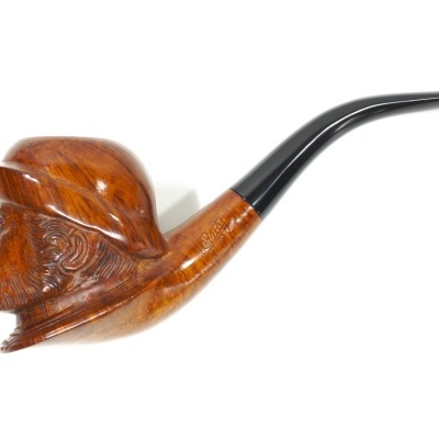 Piteira de fumar em madeira esculpida com forma de cabeça de homem e bocal preto.