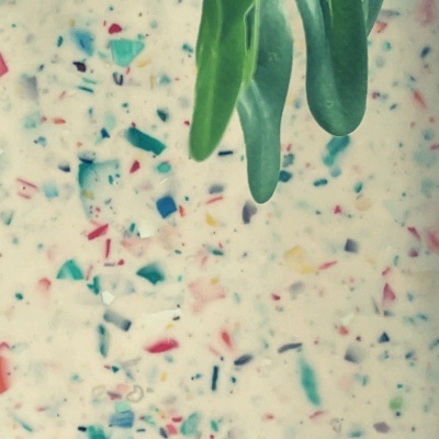 Folhas verdes sobre superfície branca com padrão multicolorido